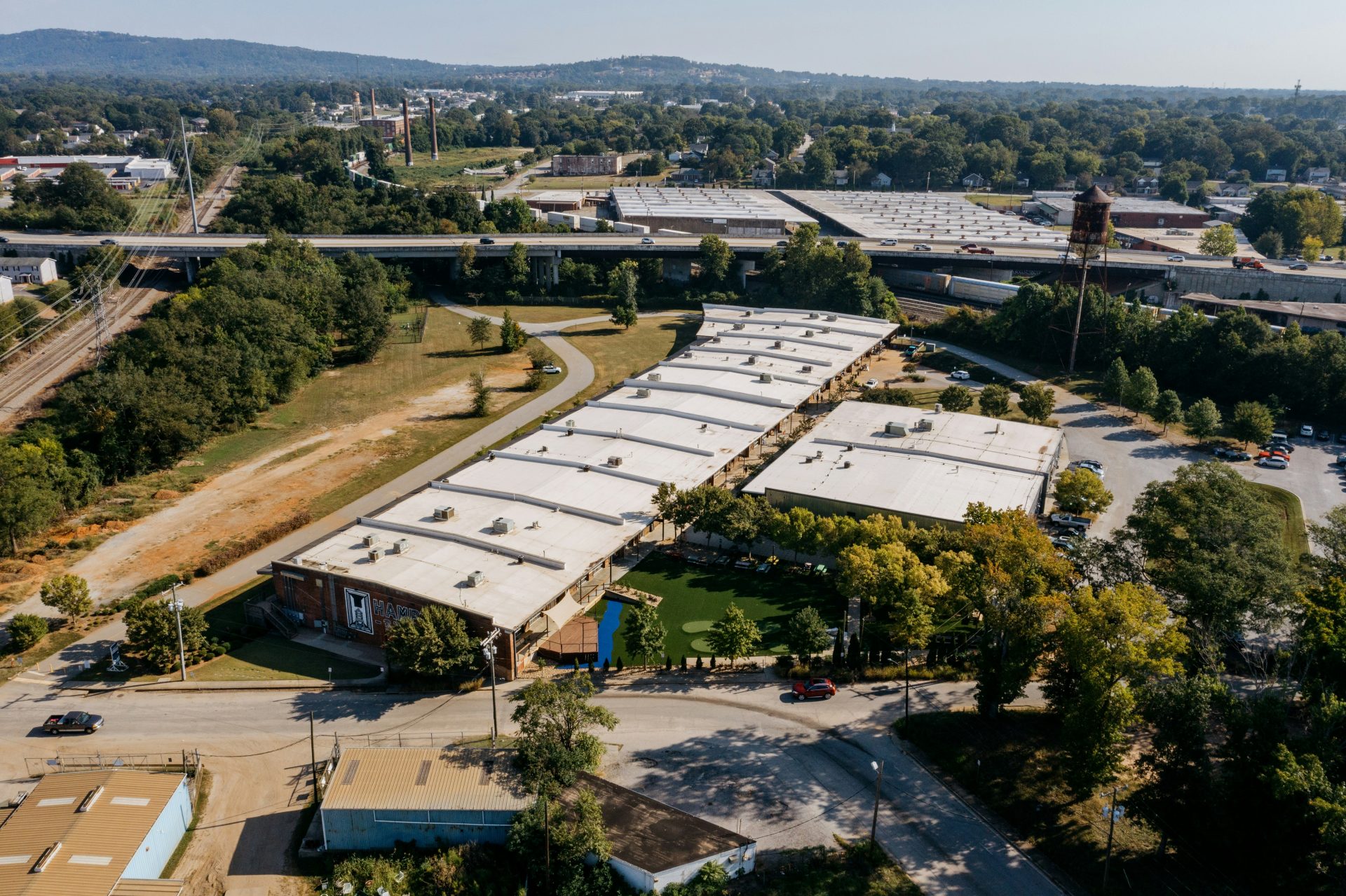 Aerial view of industrial buildings and highway overpass.